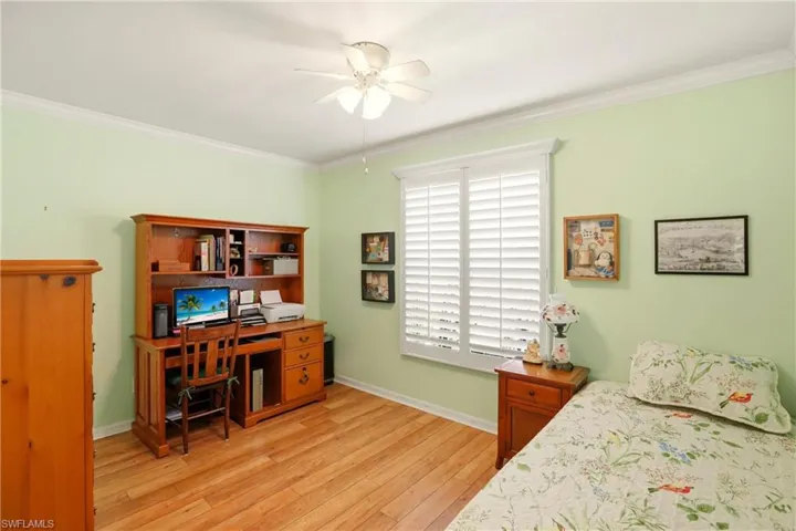 Bedroom featuring crown molding, light wood-type flooring, and ceiling fan