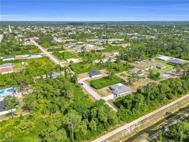 Aerial view of property's location featuring a tree filled landscape