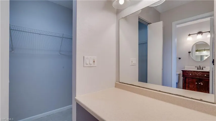 Primary bedroom walk in closet with vanity area