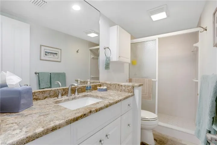Guest bath with granite counter and walk-in shower.