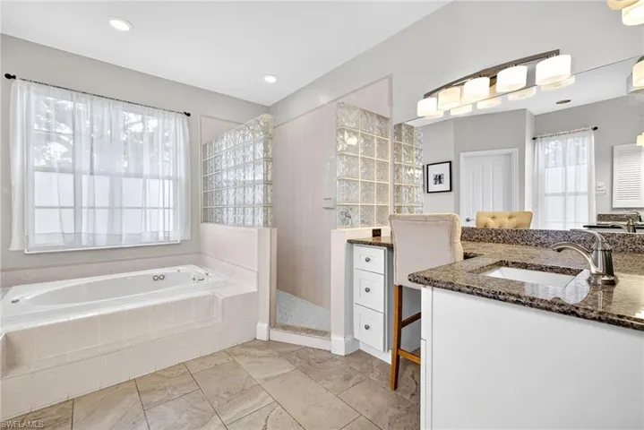Primary bathroom with a garden tub, vanity, and walk in shower