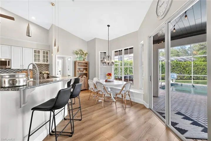 Kitchen featuring glass insert cabinets, breakfast bar, and eat in kitchen