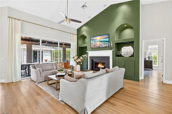 Living room featuring high ceilings, access to the lanai and wood burning fire place