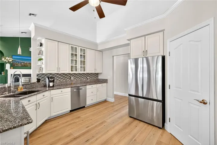 Kitchen with appliances with stainless steel finishes, granite countertops, step in pantry