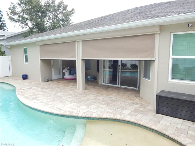 Outdoor swimming pool with integrated steps, paver patio, retractable patio screens, and sliding glass doors