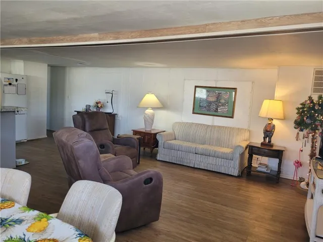 Living room featuring dark hardwood / wood-style floors and beam ceiling