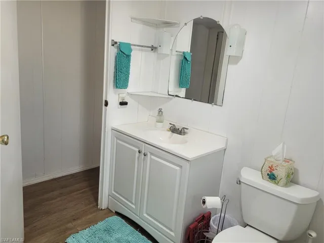 Bathroom with vanity, toilet, and wood-type flooring