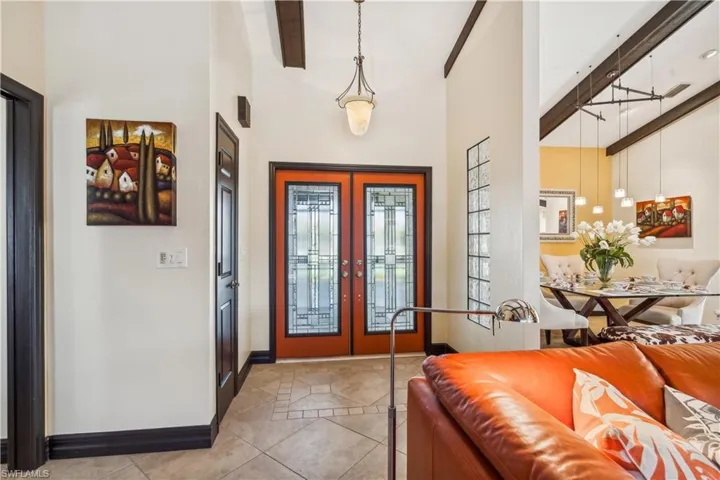 Entrance Foyer featuring french doors (Impact), light tile patterned floors, high vaulted - beam accented ceilingTile Floors flow throughout the entire first floor