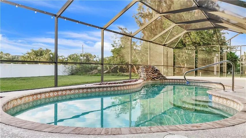 View of pool featuring a lawn and glass enclosure