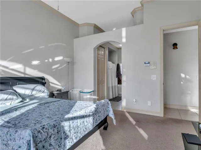 Bedroom with light colored carpet and ornamental molding