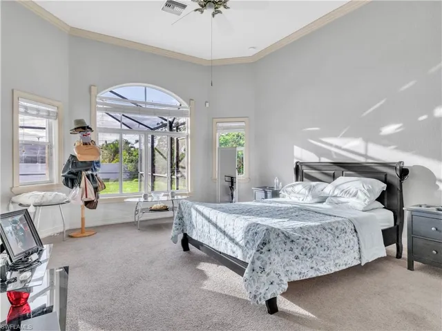 Bedroom with ceiling fan, crown molding, and carpet floors