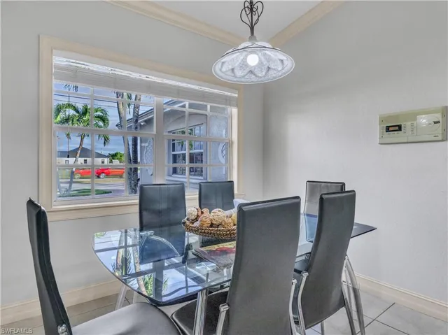 Tiled dining room featuring crown molding