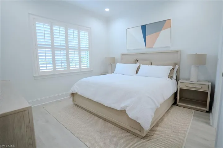 Bedroom with light wood-type flooring, recessed lighting, and ornamental molding