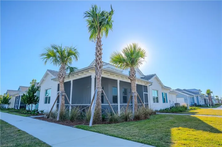 View of home's exterior with a sunroom and a lawn
