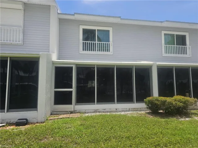 Rear view of property with a yard