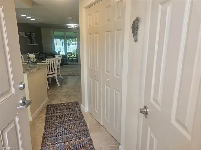 Hallway featuring light tile patterned floors and baseboards