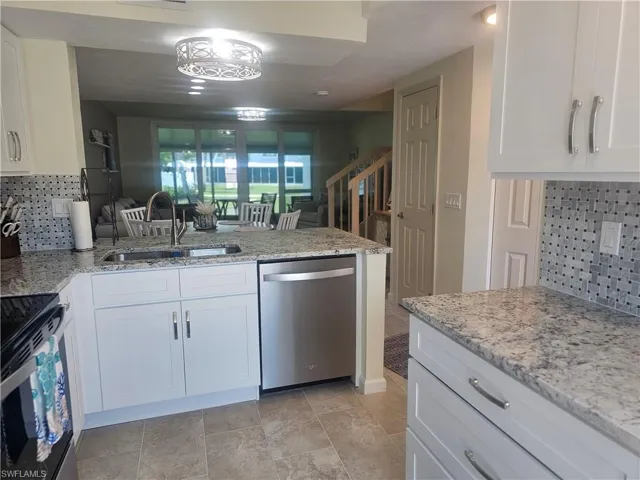 Kitchen featuring dishwasher, range, a peninsula, and backsplash