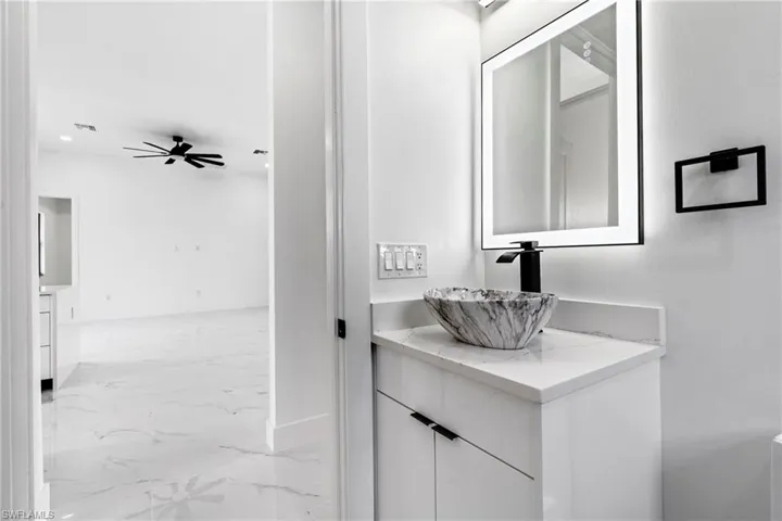 Bathroom with a ceiling fan, visible vents, marble finish floor, and vanity