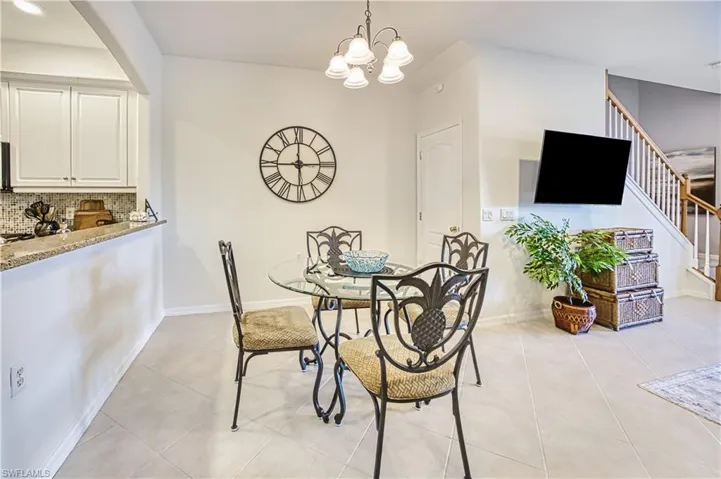 Dining space with suspended lighting and light tile patterned floors