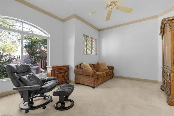 Guest Bedroom featuring ornamental molding, light colored carpet, and ceiling fan