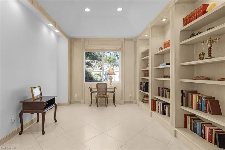 Den / flex room with built in shelves and light tile patterned floors