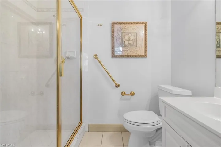Guest Bathroom featuring tile patterned floors, toilet, a shower with shower door, and vanity