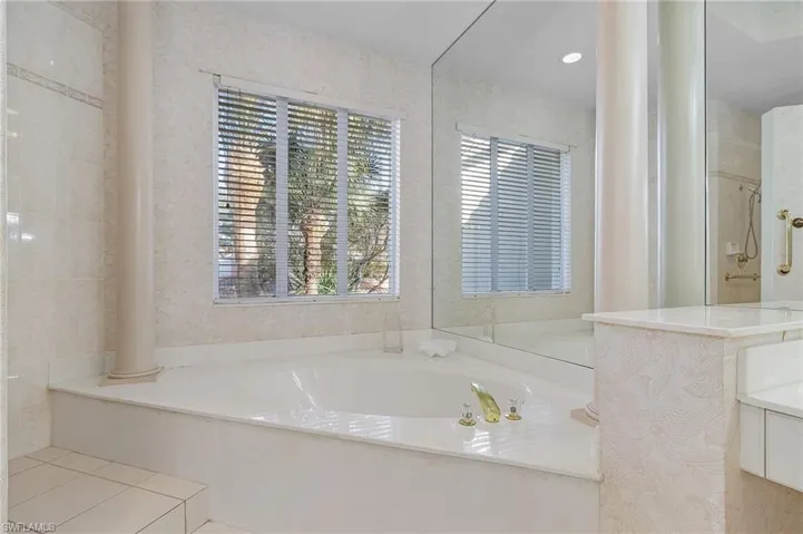 Bathroom featuring plus walk in shower and ornate columns