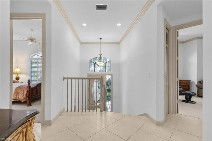 Foyer entrance featuring ornamental molding, light tile patterned floors, and ceiling fan