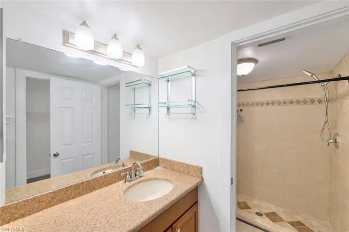 Full bathroom with vanity and a shower stall
