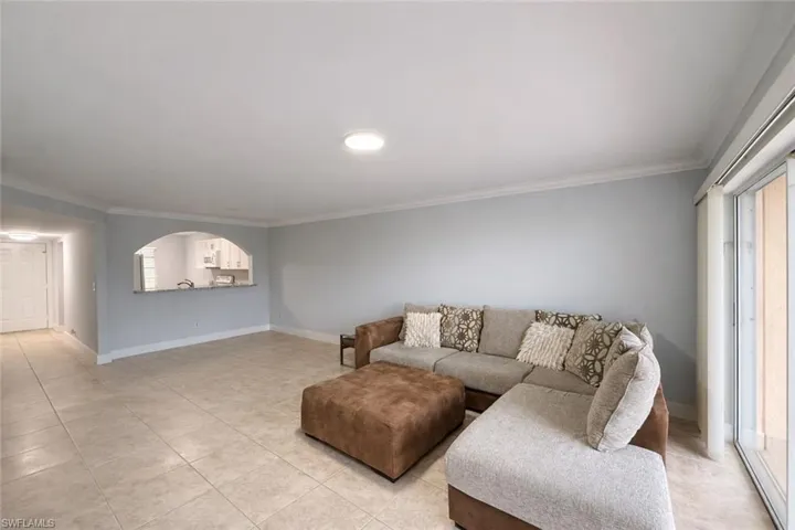 Living room featuring crown molding and light tile patterned floors