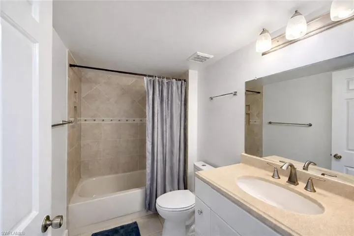 Full bathroom featuring vanity, light tile patterned floors, and shower / tub combo