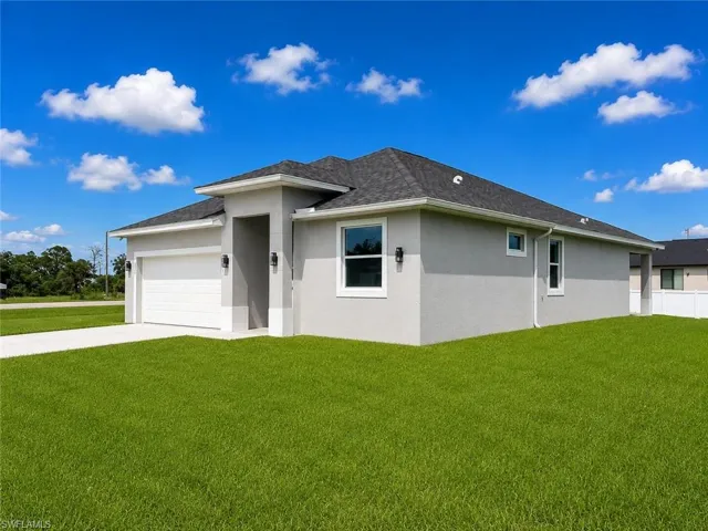 Contemporary single-story residence featuring a two-car garage, stucco exterior, dark shingle roof, and white-framed windows