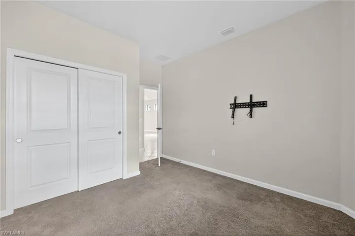 Unfurnished bedroom with carpet flooring and a closet
