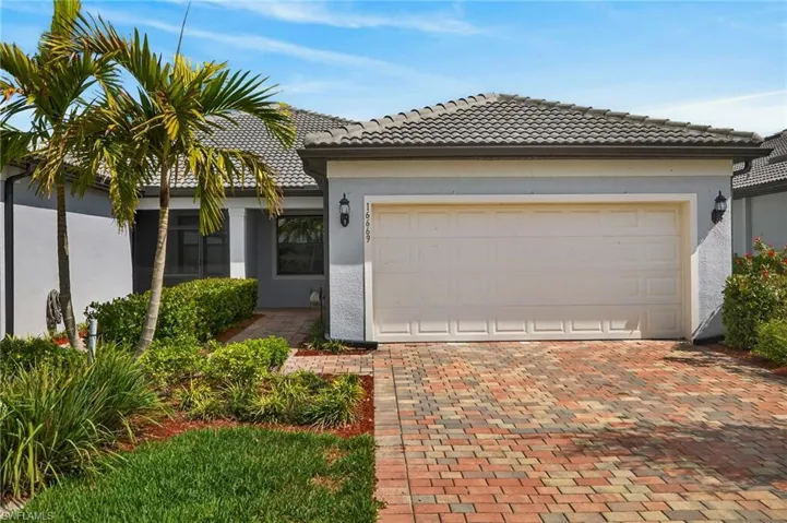 View of front of home featuring stucco siding, decorative driveway, an attached garage, and a tiled roof