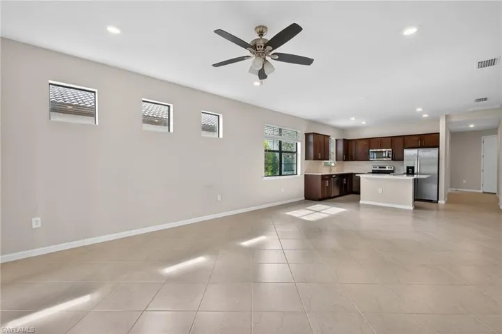 Living/Dining Room featuring open floor plan, light countertops, dark wood finish cabinets, a center island, and recessed lighting