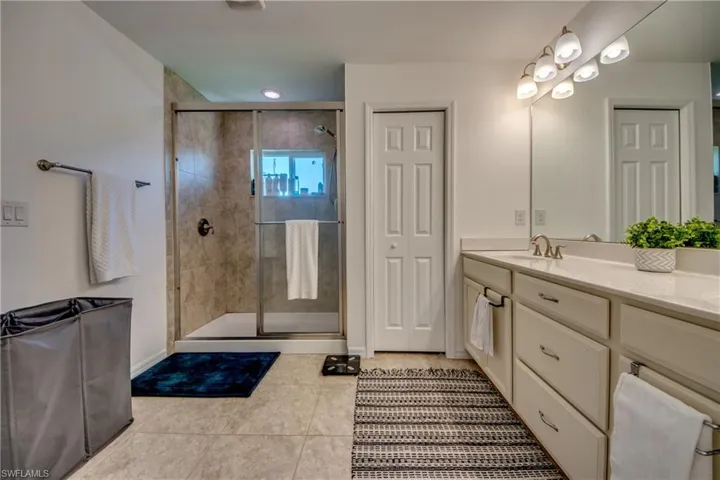 Bathroom featuring vanity, tile patterned flooring, and an enclosed shower