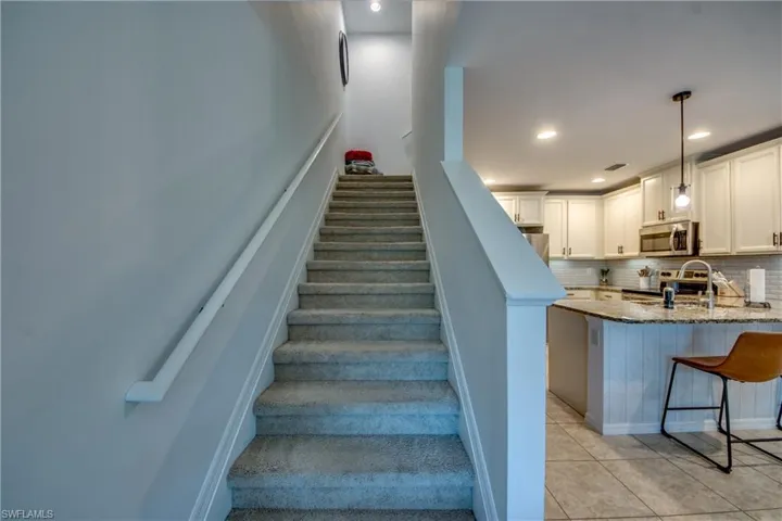 Staircase featuring light tile patterned flooring