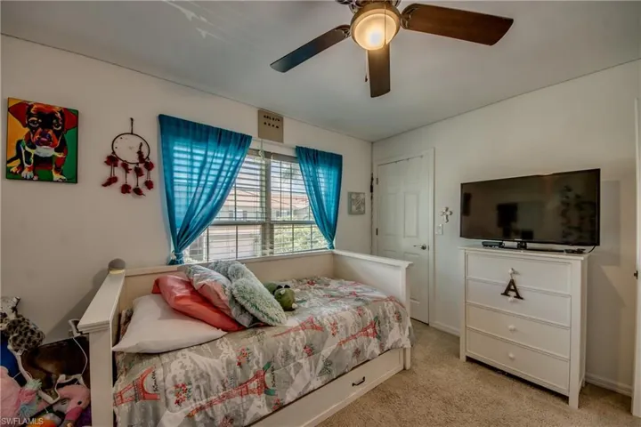 Bedroom with light colored carpet and ceiling fan