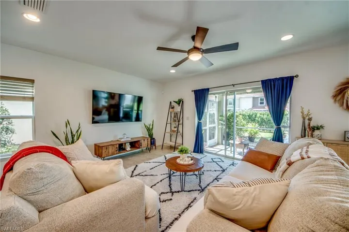 Living room with plenty of natural light, ceiling fan, and carpet flooring