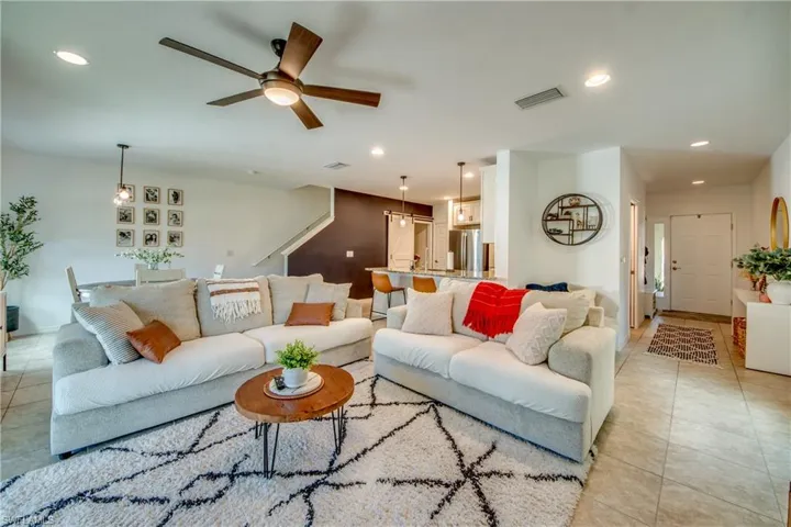 Living room with light tile patterned flooring and ceiling fan