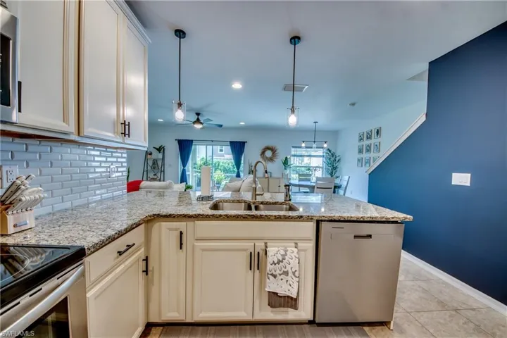 Kitchen with ceiling fan, pendant lighting, sink, dishwasher, and light tile patterned floors