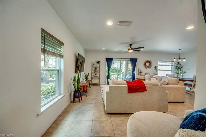 Living room with light tile patterned flooring and ceiling fan