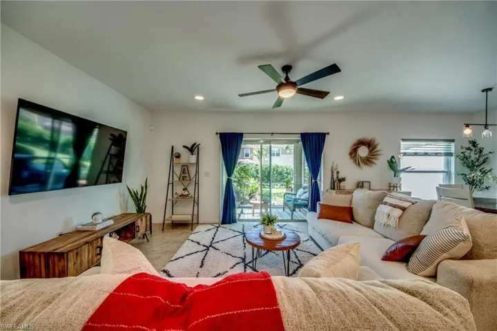 Living room with carpet and ceiling fan with notable chandelier