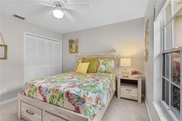 Carpeted bedroom featuring a closet and ceiling fan