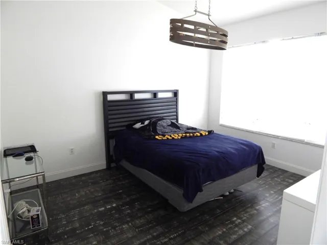Owners Bedroom with dark hardwood / wood-style flooring