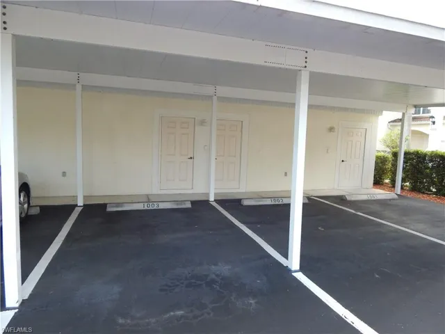 View of parking / parking lot with a carport and storage