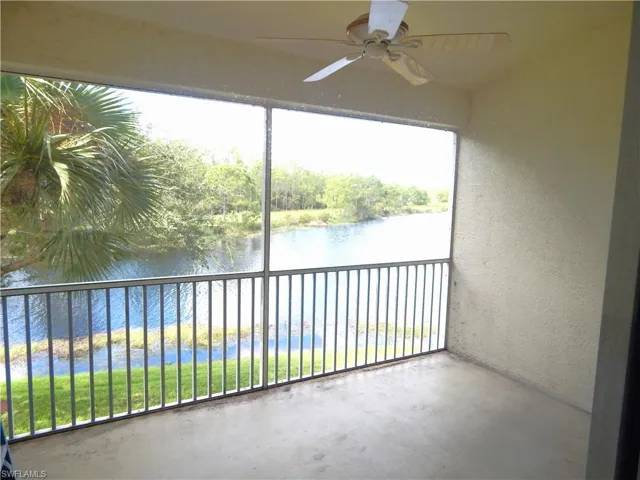 Unfurnished sunroom featuring a water view, ceiling fan, and plenty of natural light
