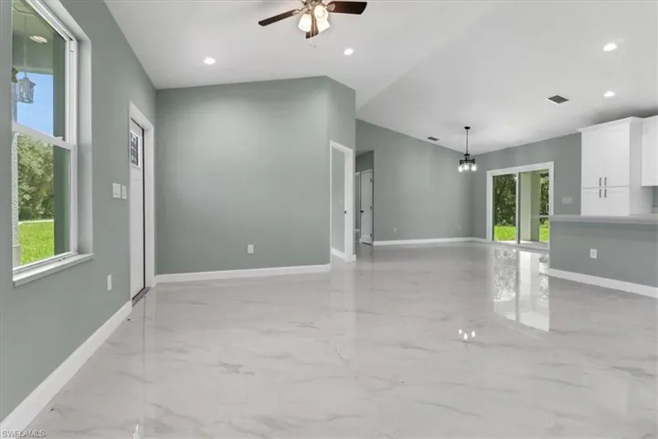 Unfurnished living room with ceiling fan and a healthy amount of sunlight
