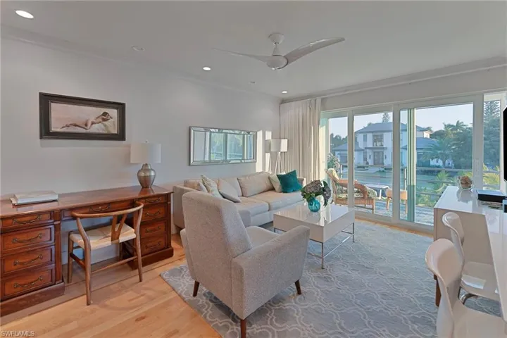 Living room with light wood-style floors, ornamental molding, recessed lighting, a ceiling fan, and a desk