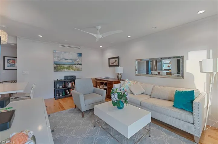 Living room featuring wood finished floors, ceiling fan, recessed lighting, and ornamental molding
